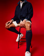 Men sitting in red room with compression socks.