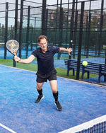 Ronald de Boer running towards the ball on a blue court.