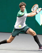 Robin Haase playing tennis with green shorts on.