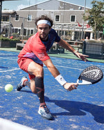 Uriel Maarsen wearing a red shirt and holding a black and white racket.