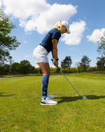 Romy Meekers standing in grass holding a golf club.