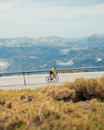 A person on a bike in the distance, riding up a mountain.