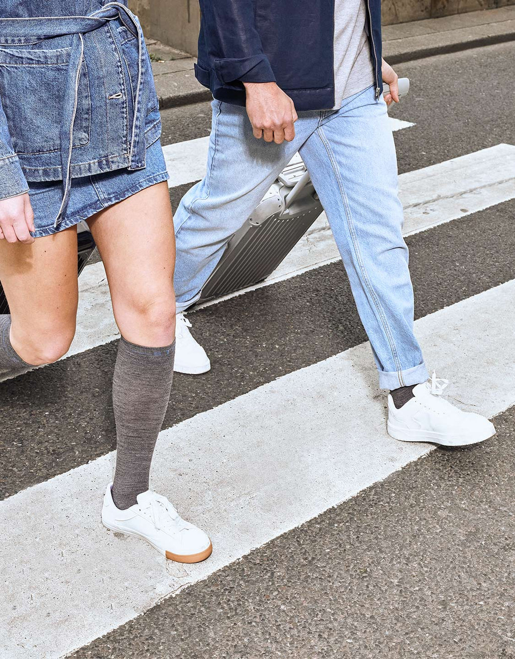 Two people waking with grey socks across a crossroad.