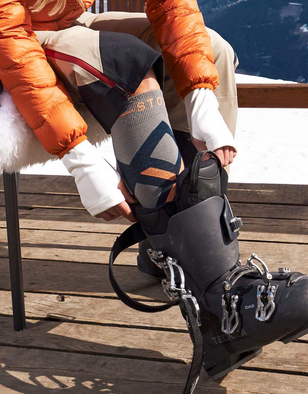 Women is putting her foot into a skiing sock.