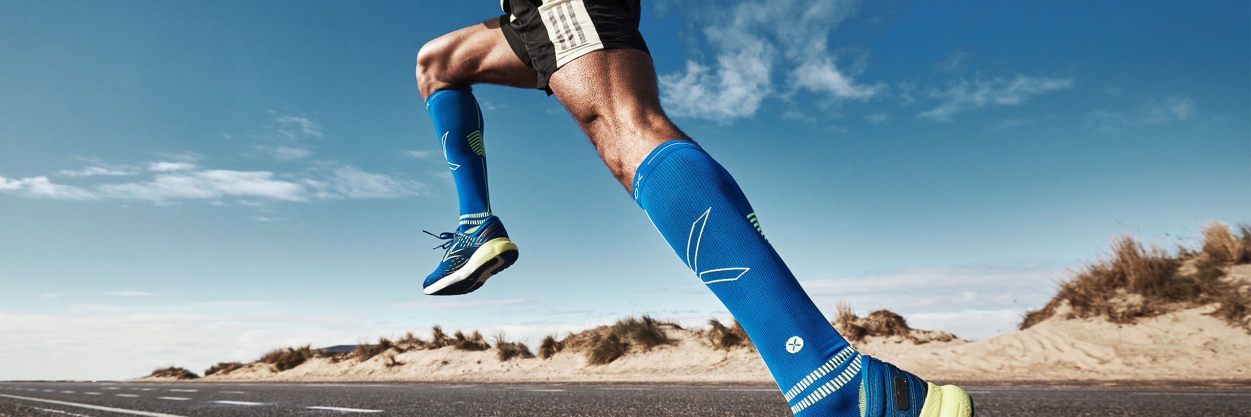 Men running on a road next to the beach