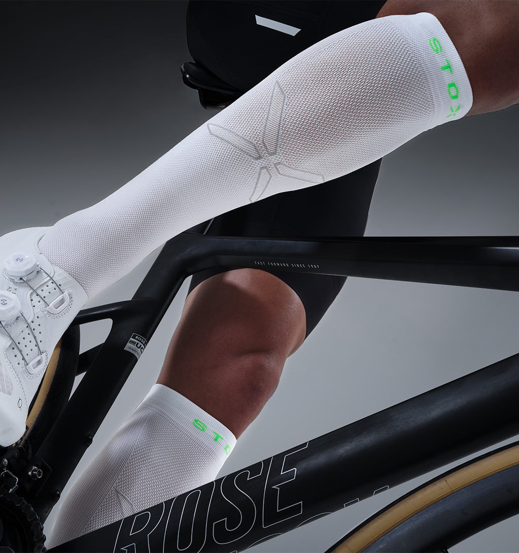 A cyclist with white long socks on.