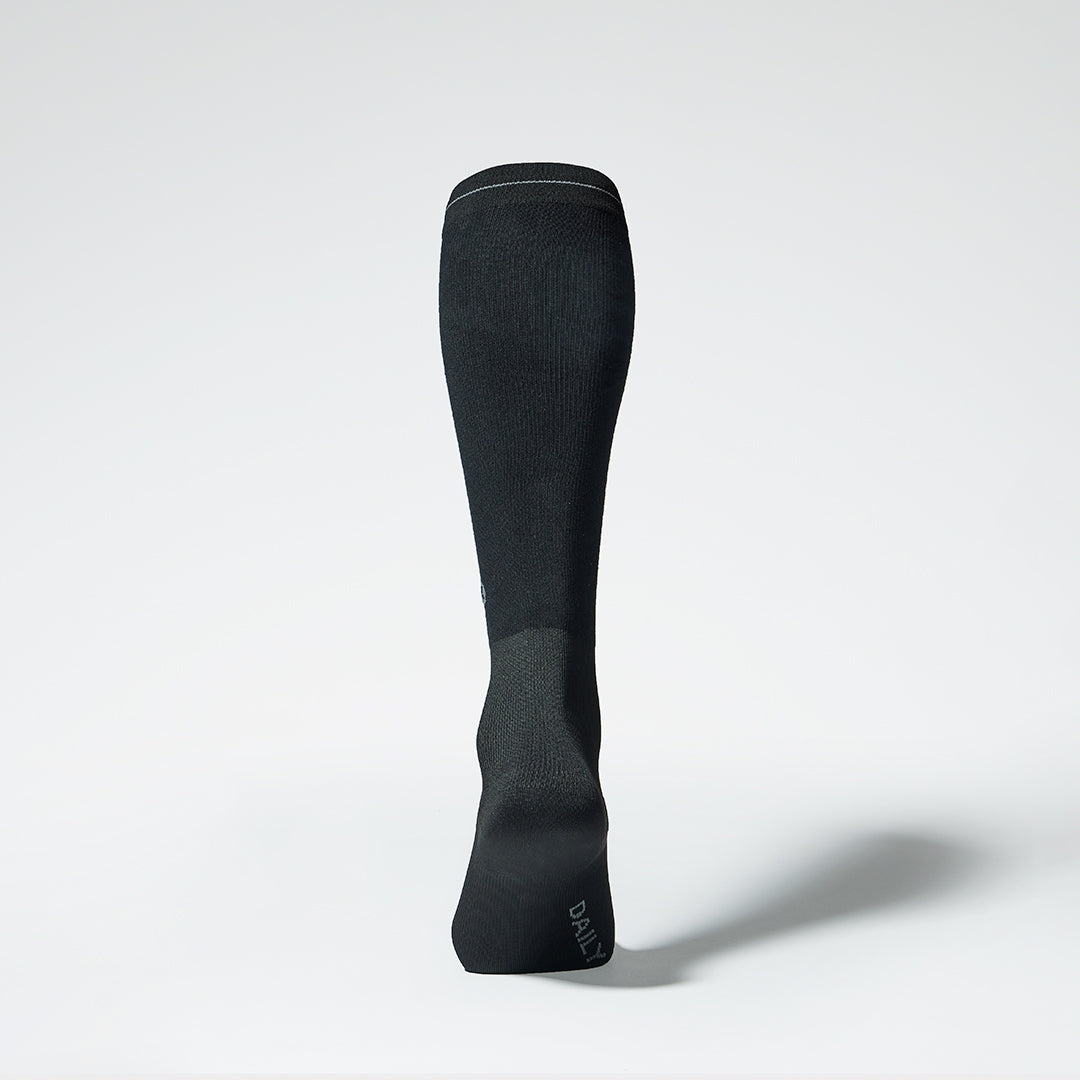 The back of a black knee high compression sock.