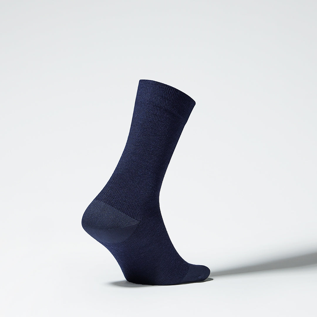 Side view of a mid-calf dark blue compression sock.
