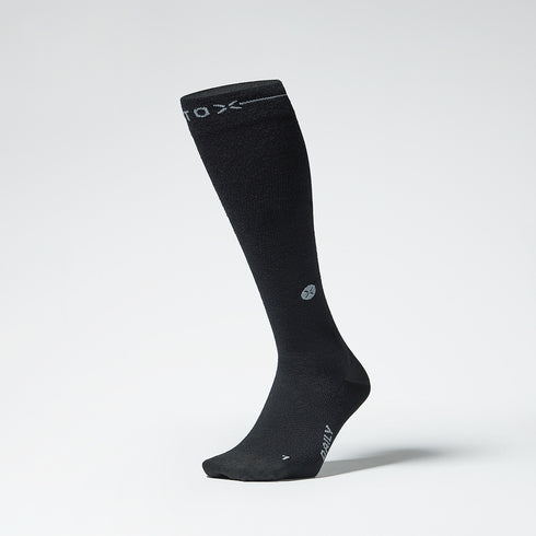 Black knee high compression sock with grey details seen from the front.
