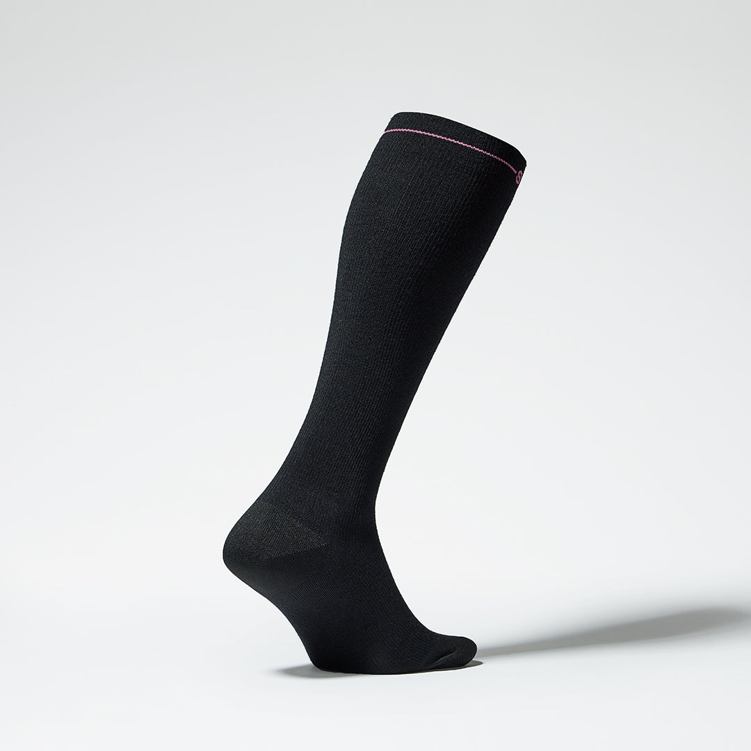 Side view of a black knee high compression sock with fuchsia details.