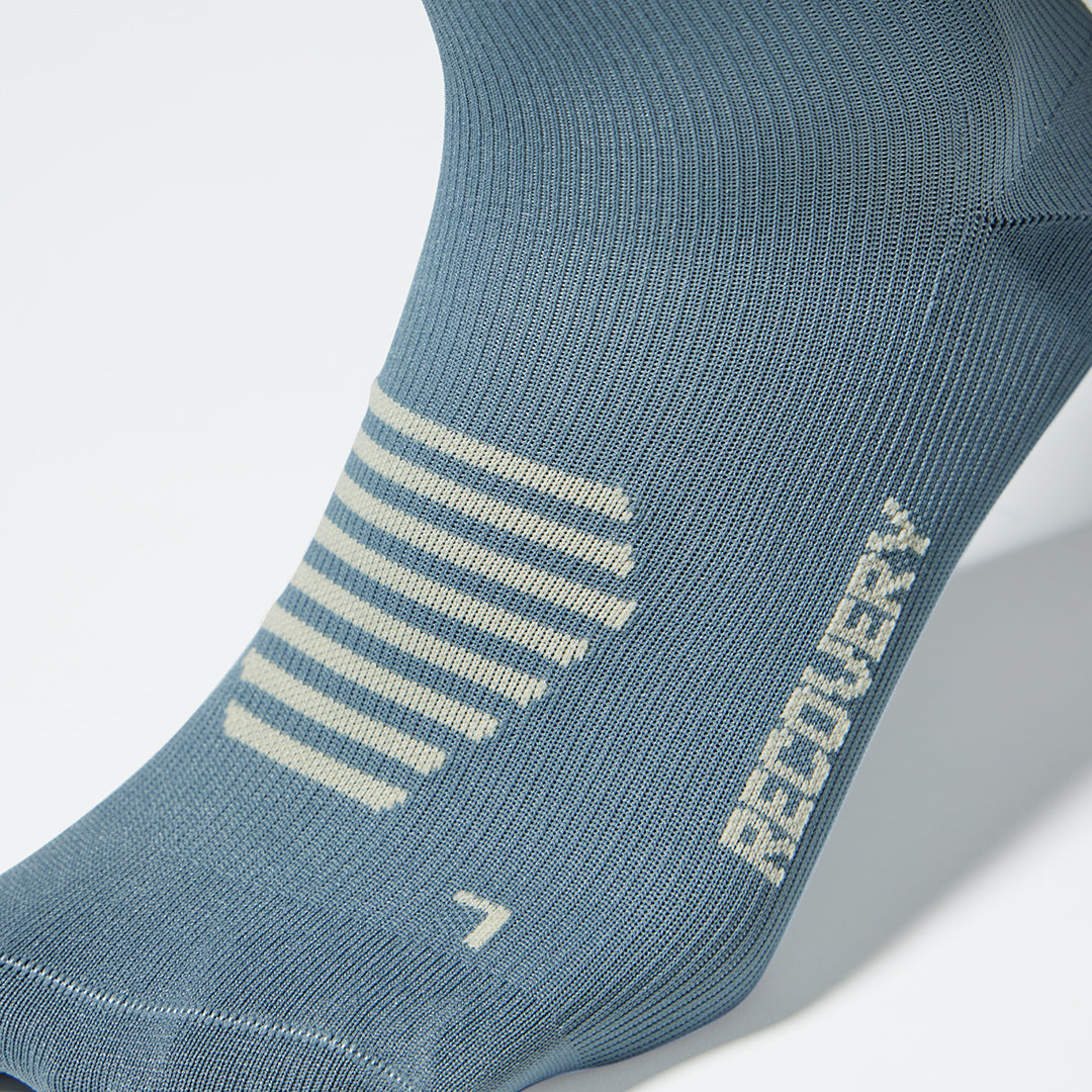Close up of a compression sock in grey with beige accents.
