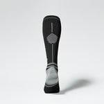 View of the back of a knee high compression sock in black with grey details.
