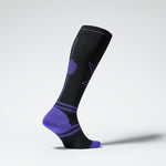 Side view of a black colored knee high compression sock with purple accents.