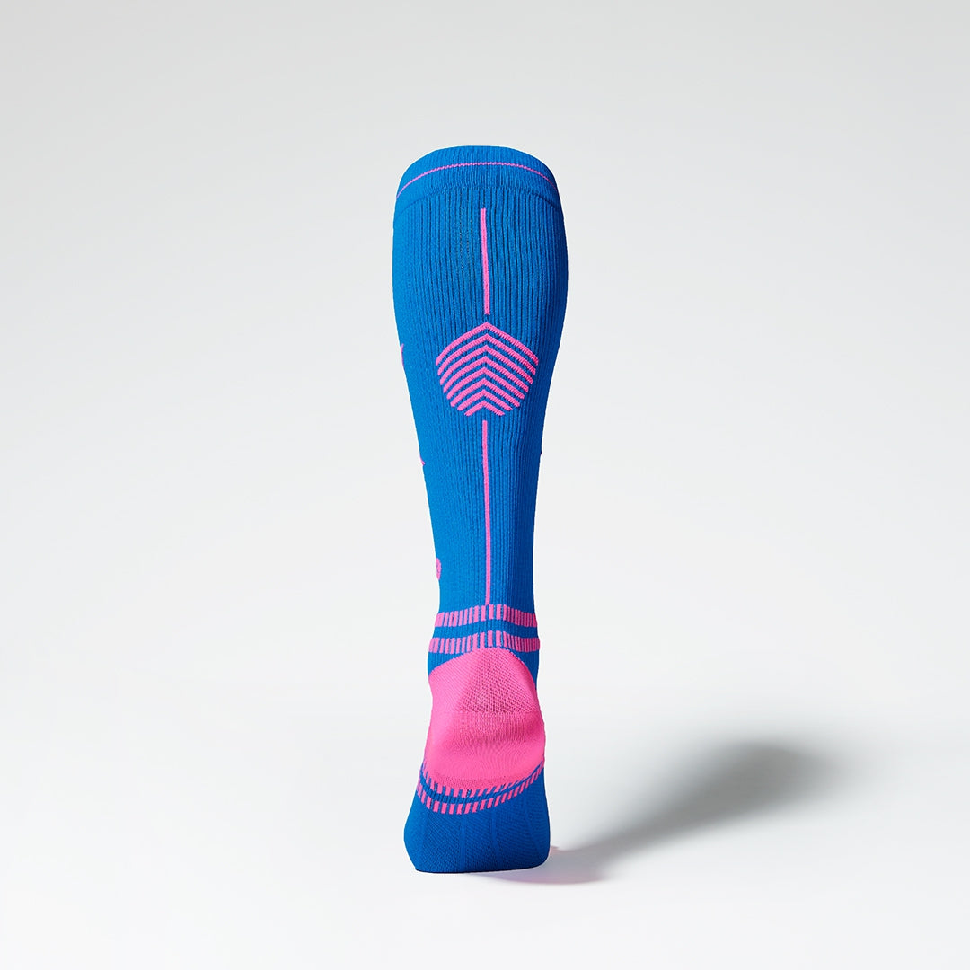 View of the back of a knee high compression sock in blue with pink details.