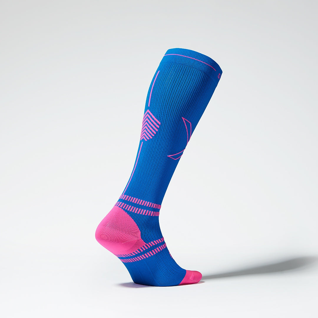 Side view of a blue colored knee high compression sock with pink accents. 