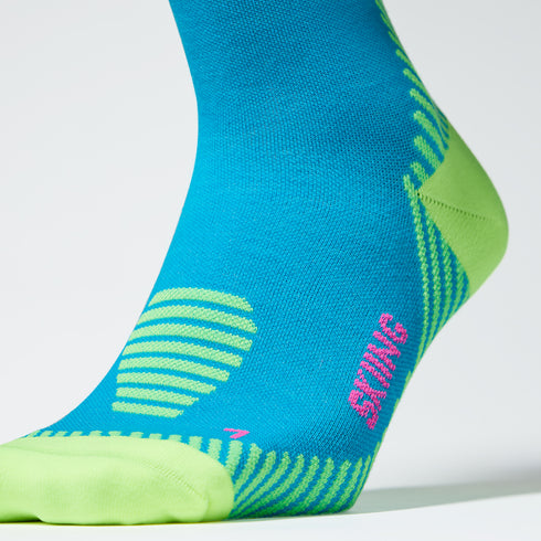 Close up of a turquoise compression sock with a yellow heel and lined details.