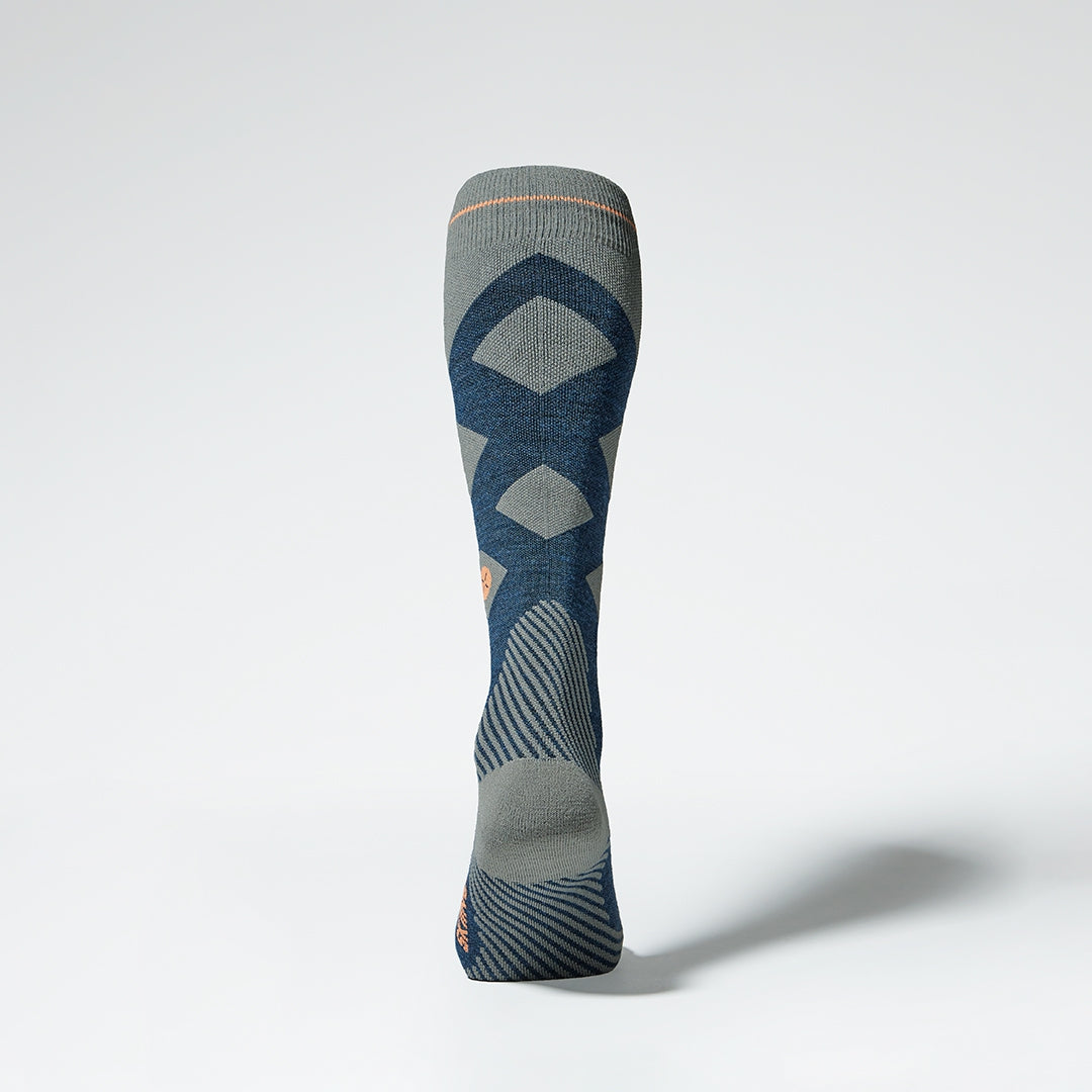 Back view of a blue grey compression skiing socks with orange details.