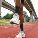 Man on a racetrack wearing black short socks.