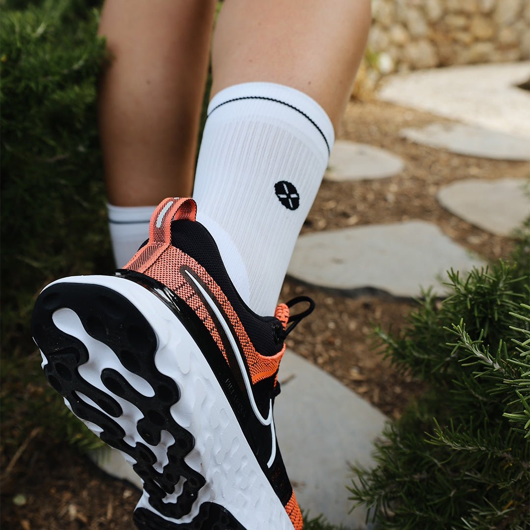 An orange sports shoe and a white sock.