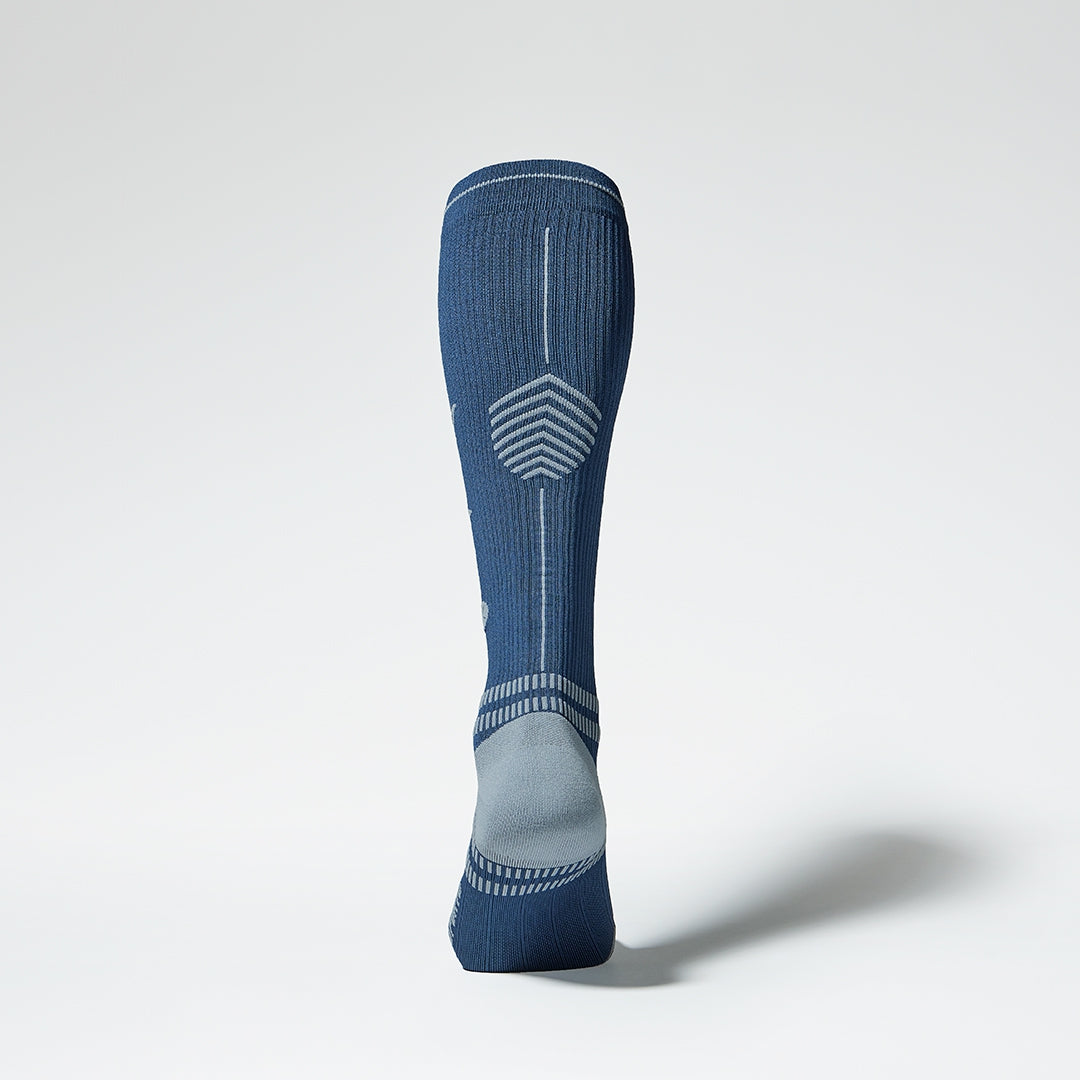  Back view of a blue knee high compression sock with grey accents.