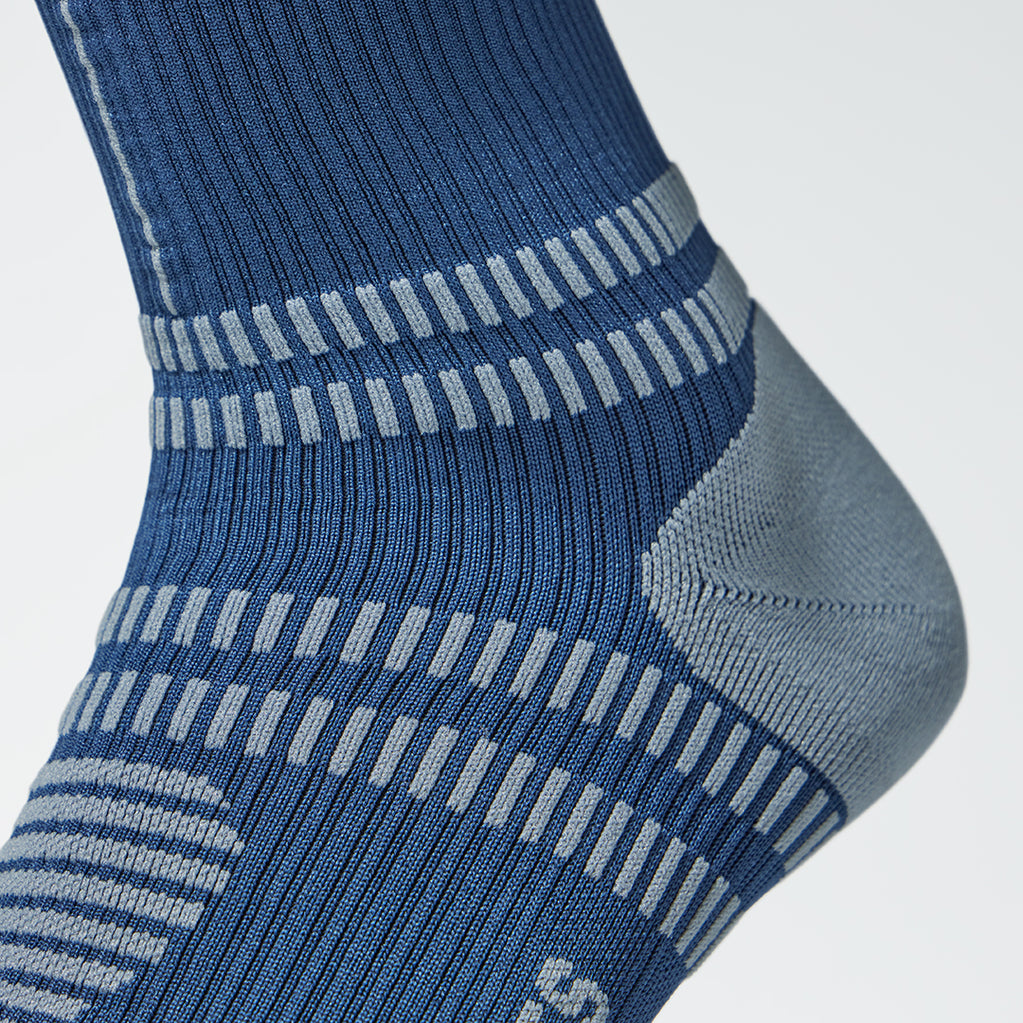 Close up of a blue compression sock with a grey heel.