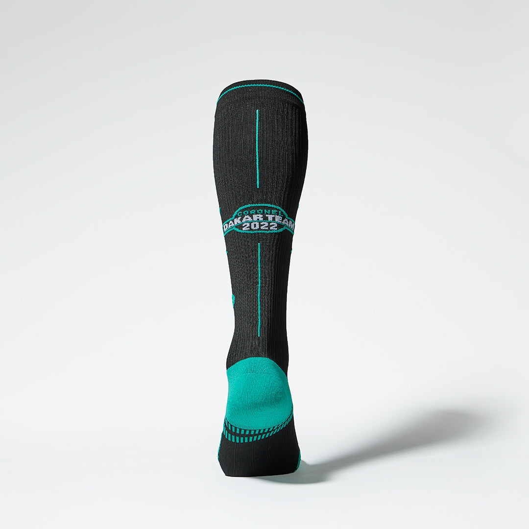 Back view of a black compression sock with blue green details.