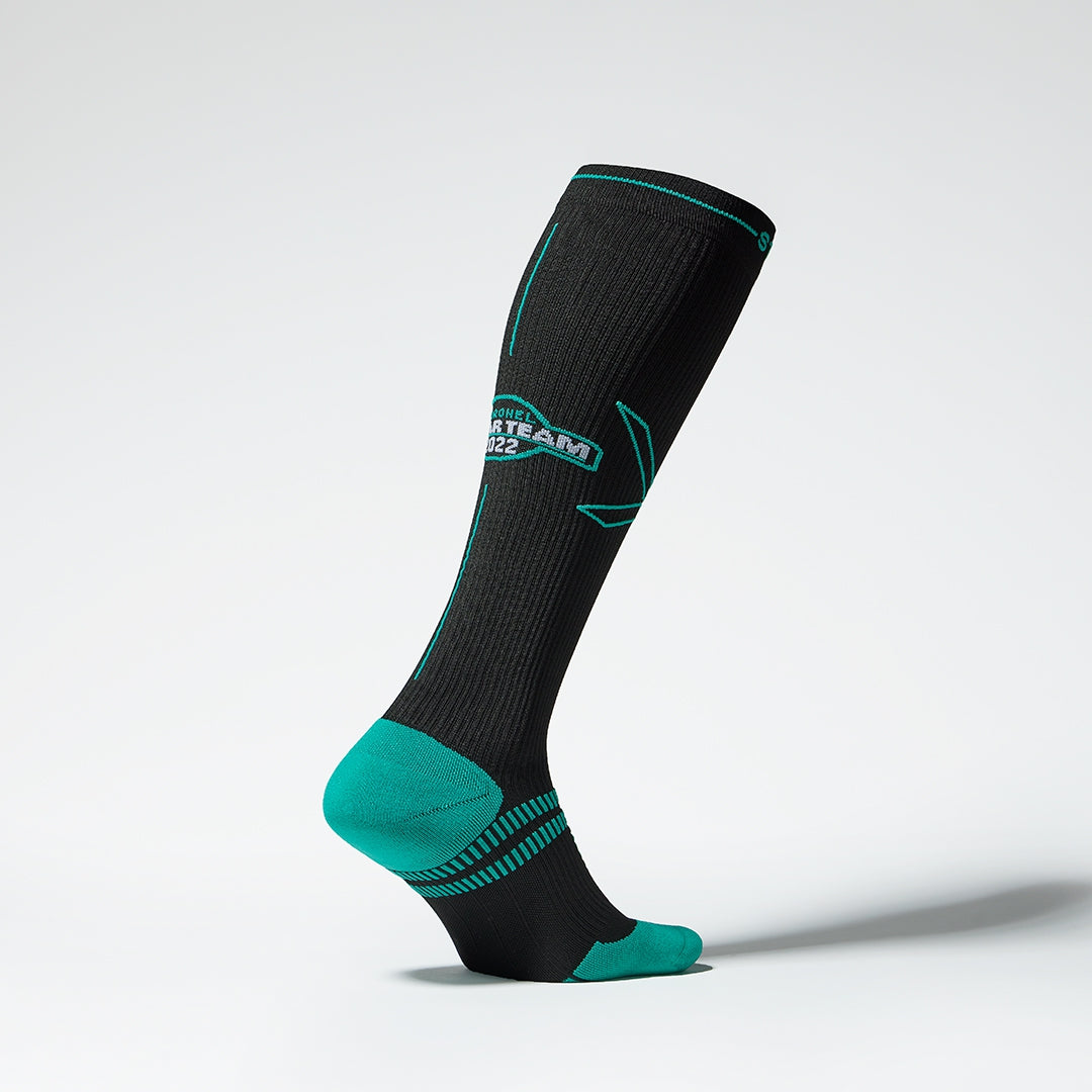 Side view of a black compression sock with blue green details.