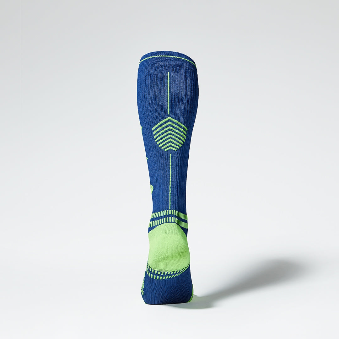 Back view of a dark blue knee high compression sock with yellow details.