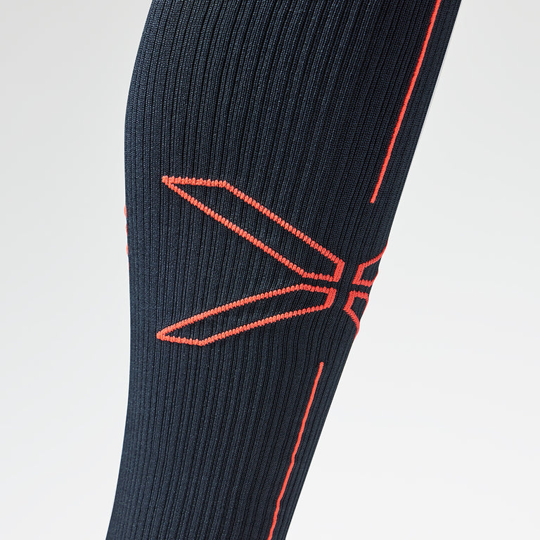 A close up of a navy blue compression sock with an orange logo.