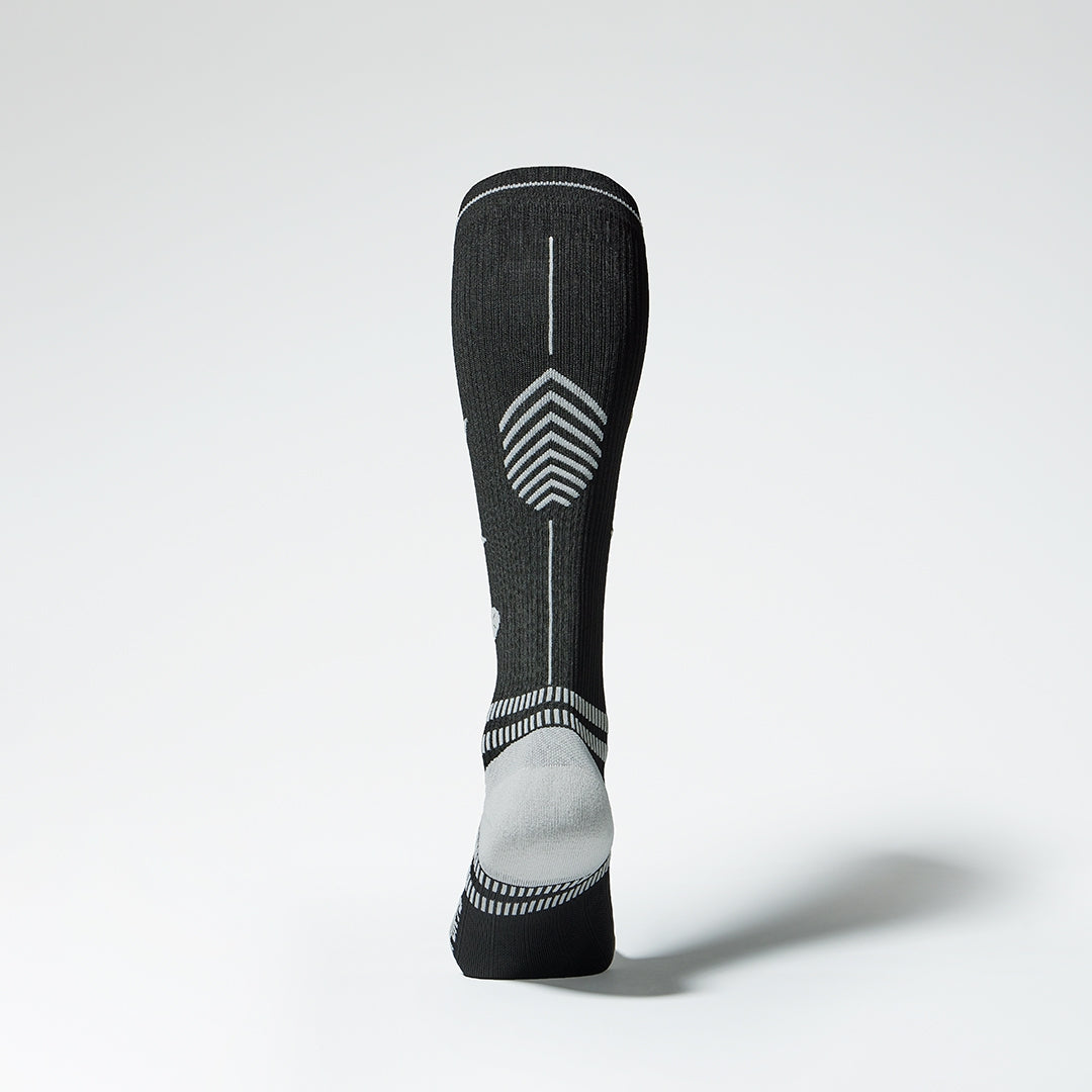 Back shot of a left footed black compression sock with grey.
