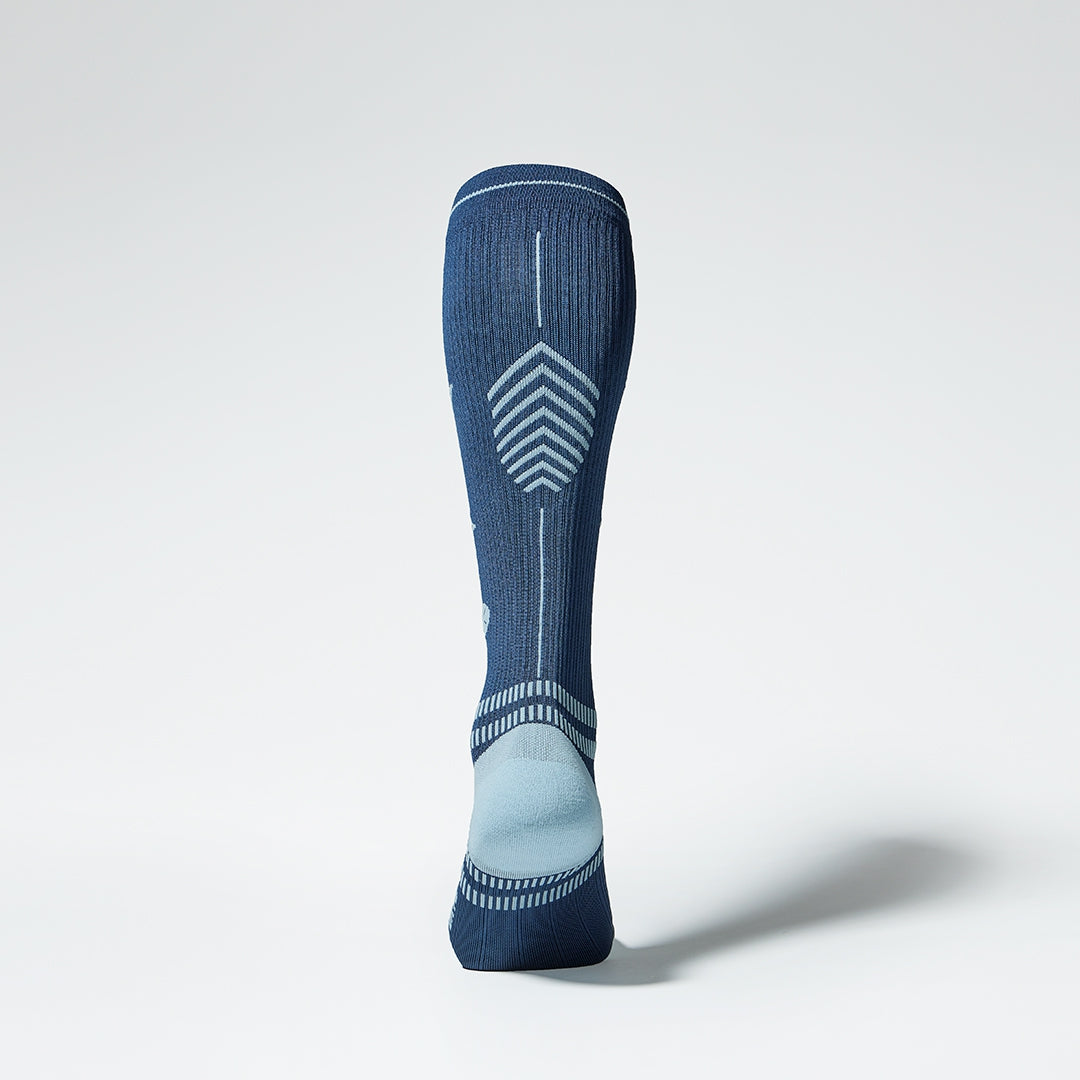Back view of a blue knee high compression sock with grey details.
