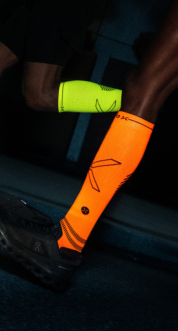 Couple running in the dark with bright orange and yellow knee high socks.