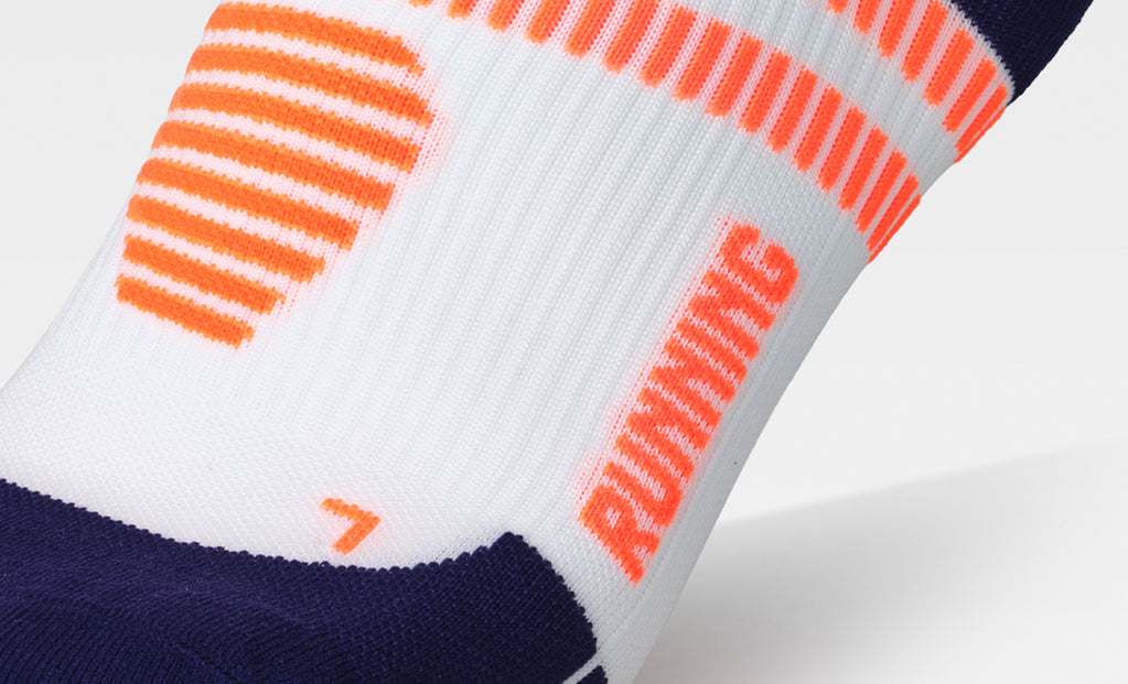Close-up of a sock with orange and blue patterns on a white background