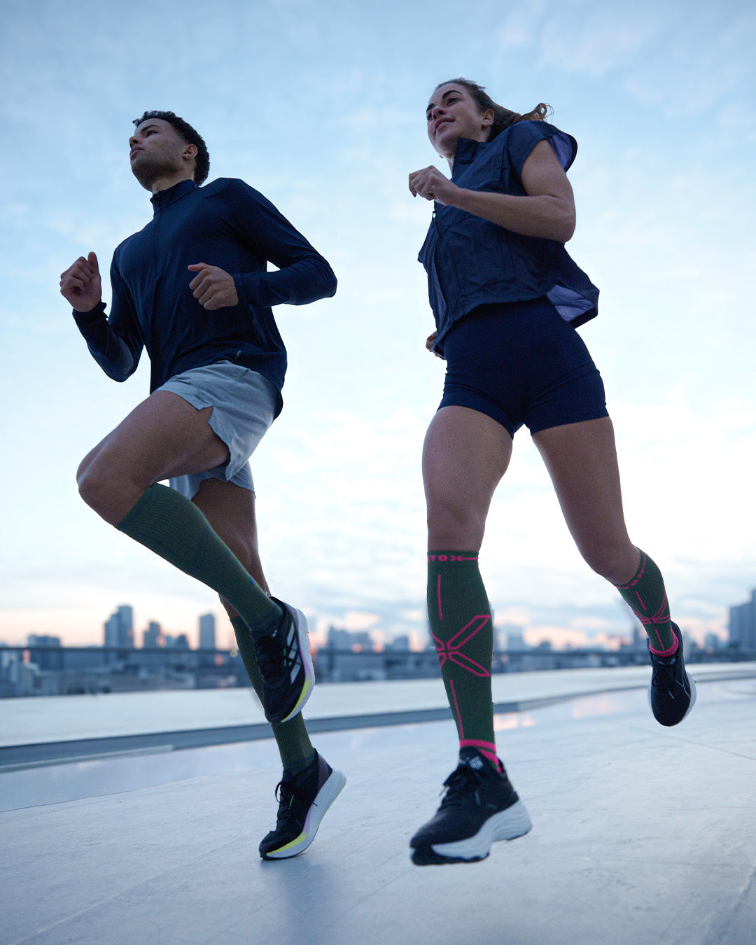 Men running on sand with compression socks.