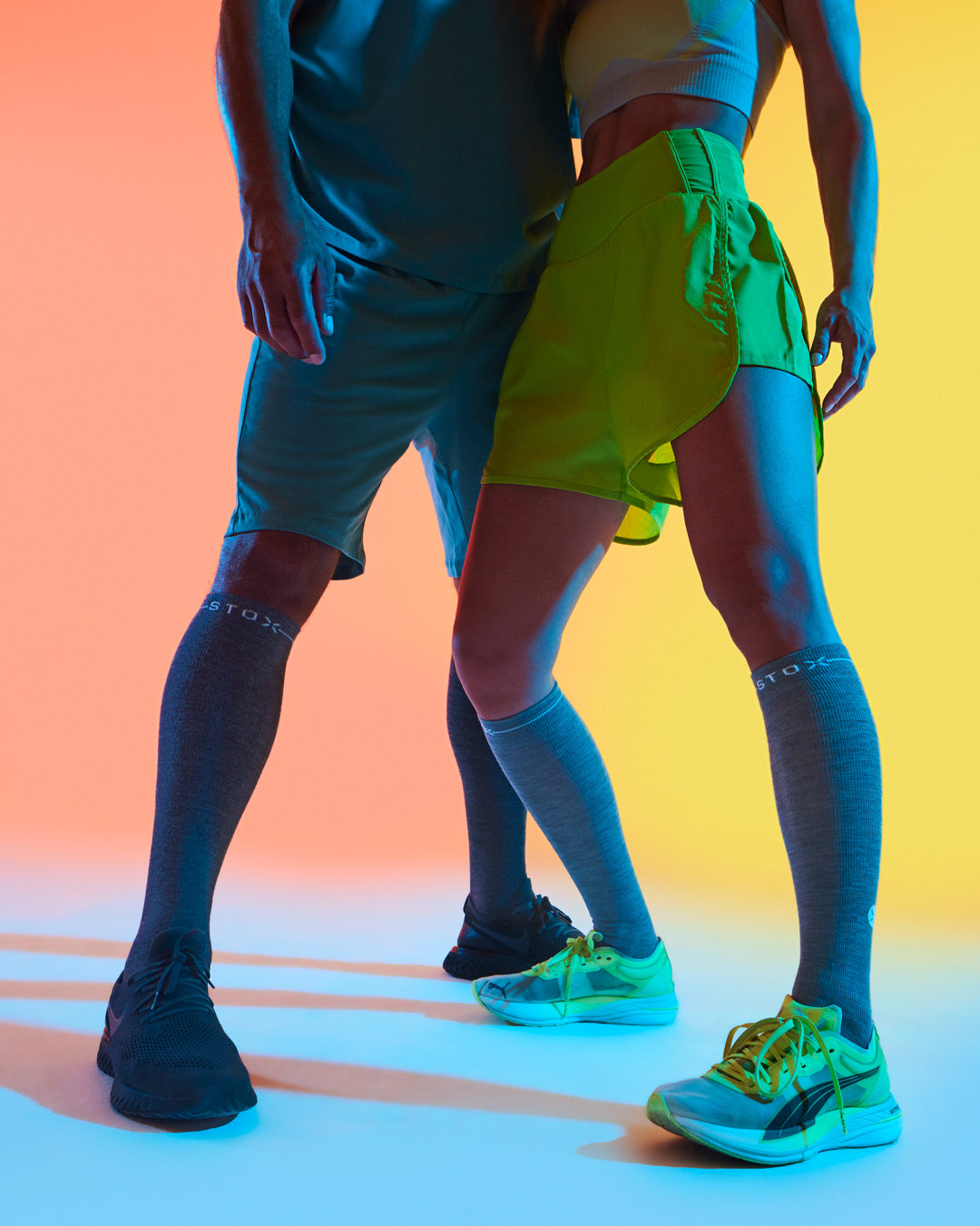 Men and woman standing with compression socks.