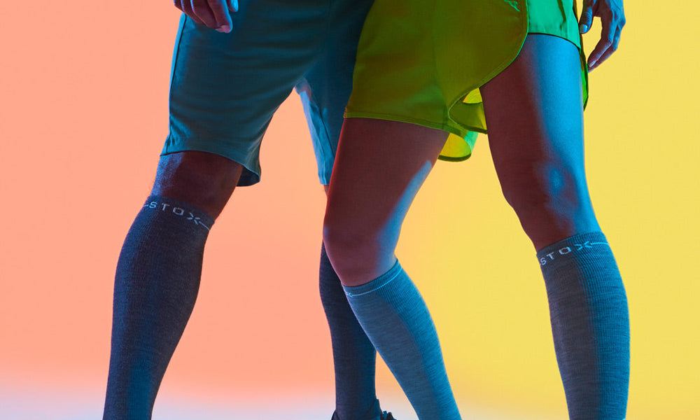 Men and woman standing with compression socks.