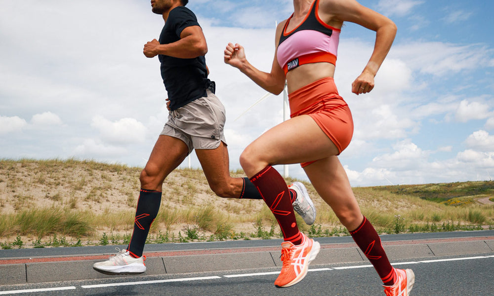 Couple running on a highway with compression socks.