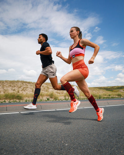 Couple running on a highway with compression socks.