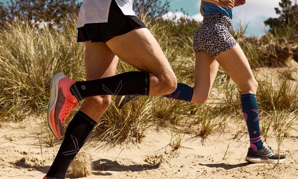 Duo running in the dunes with compression socks.