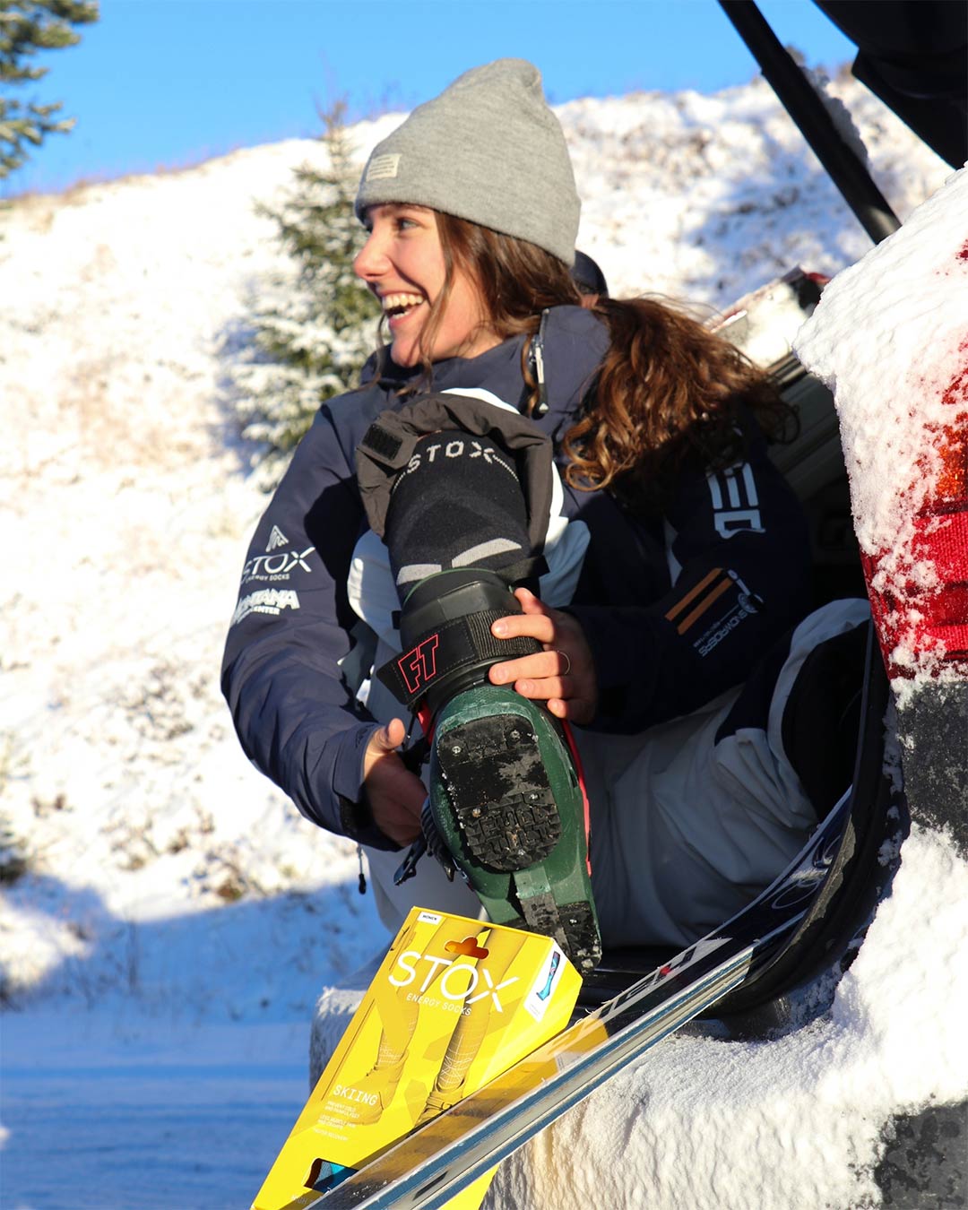 Janneke Berghuis looking away while holding a ski boot.