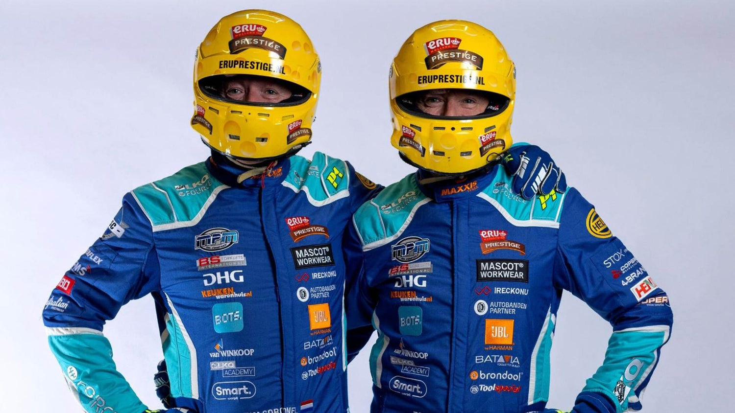 Tim and Tom Coronel posed close together with racing helmets.