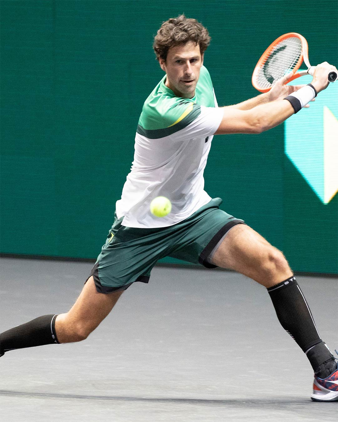  Robin Haase playing tennis with green shorts on.