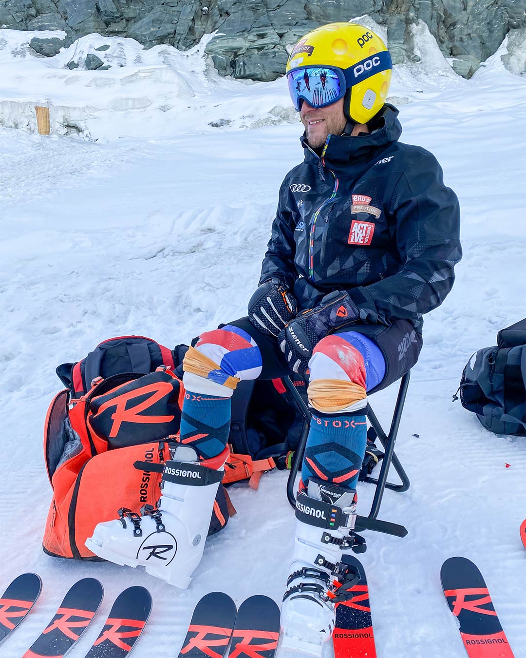 Maarten Meiners sitting on a chair in the snow with skiing shoes on. 