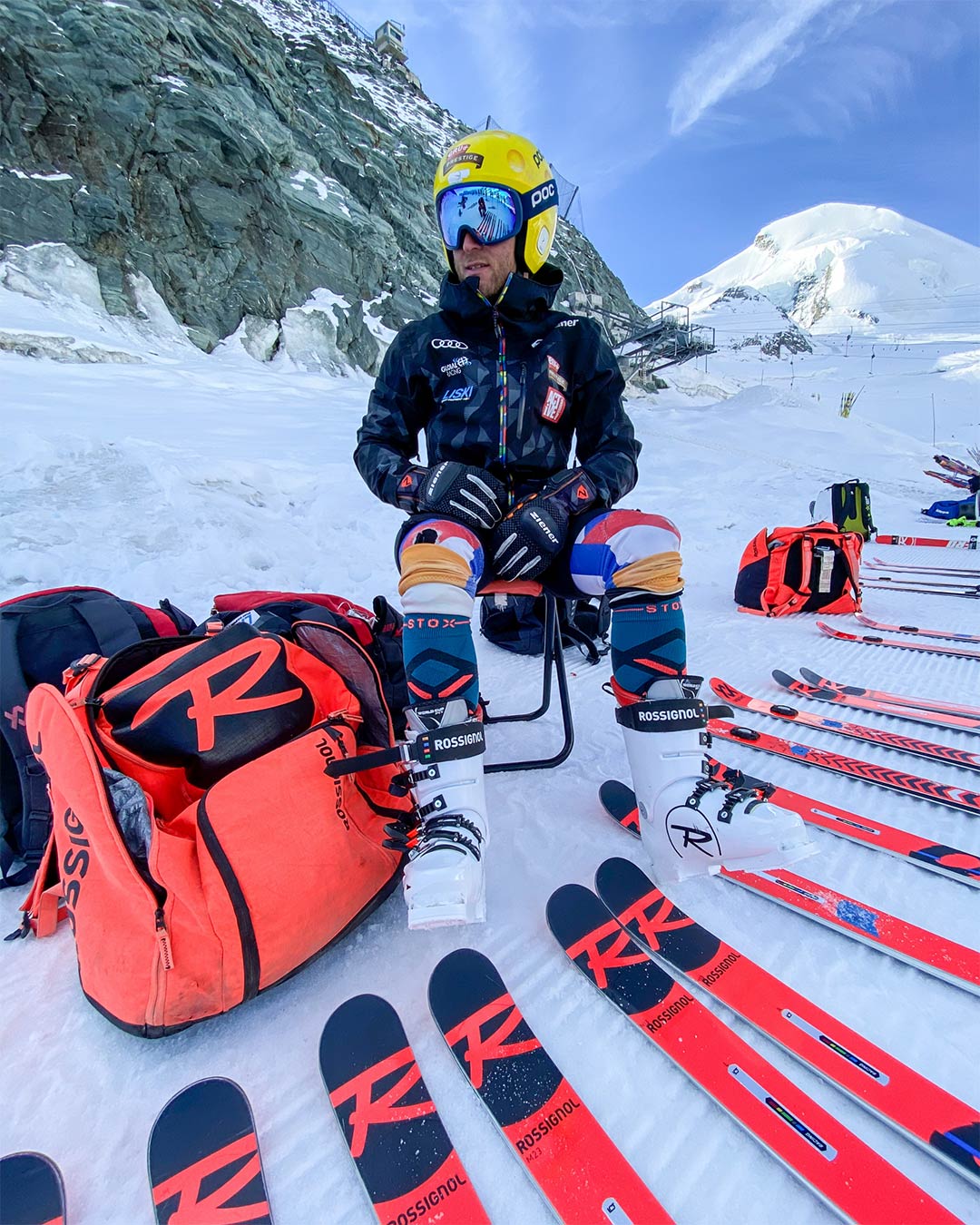 Maarten Meiners with pairs of skis laying in front of him. 