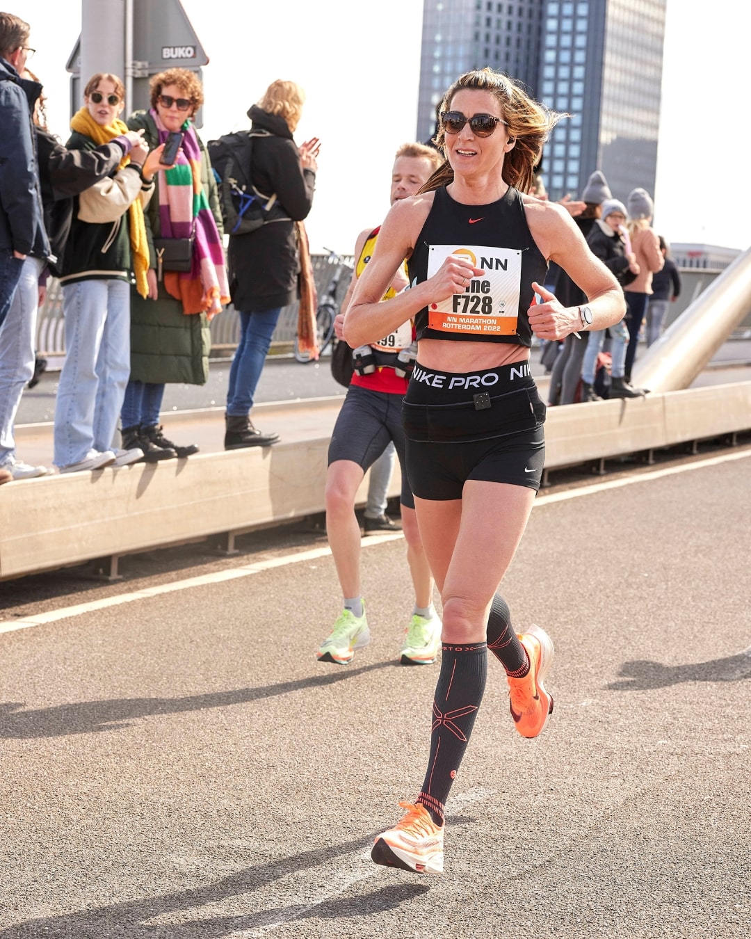 Woman running at the Rotterdam Marathon with dark blue compression socks. 