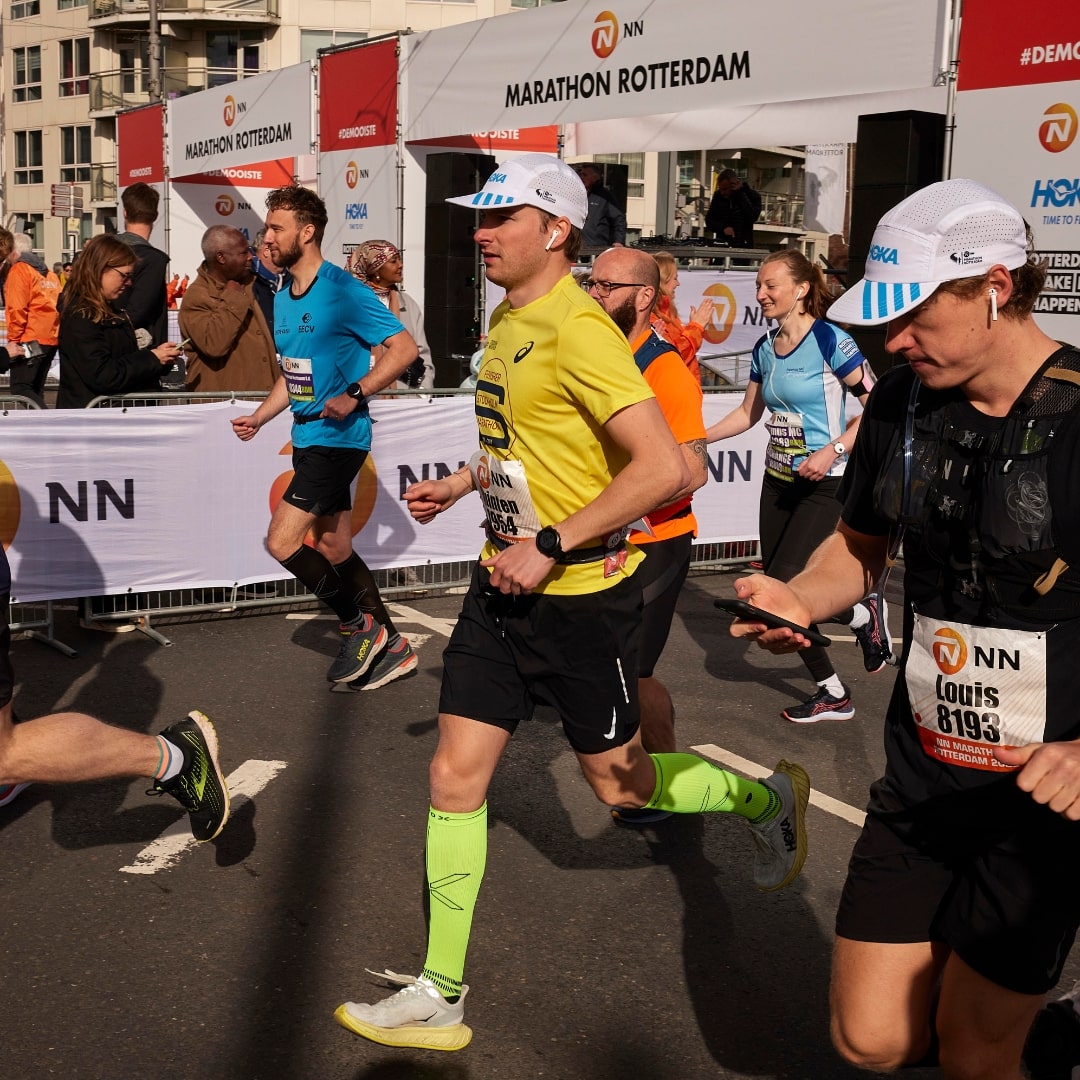 Man running at the Rotterdam Marathon with bright yellow compression socks. 