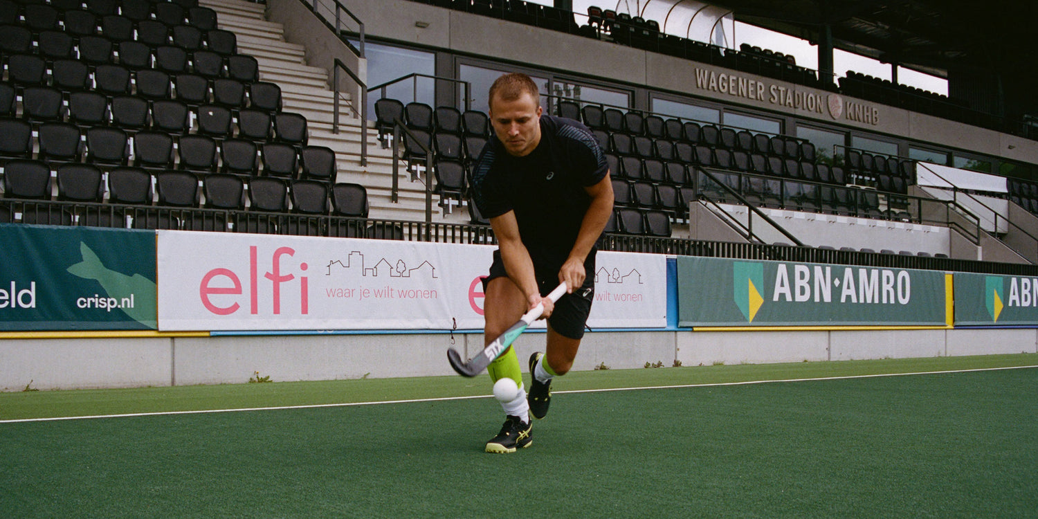 Field hockey player on field in action.