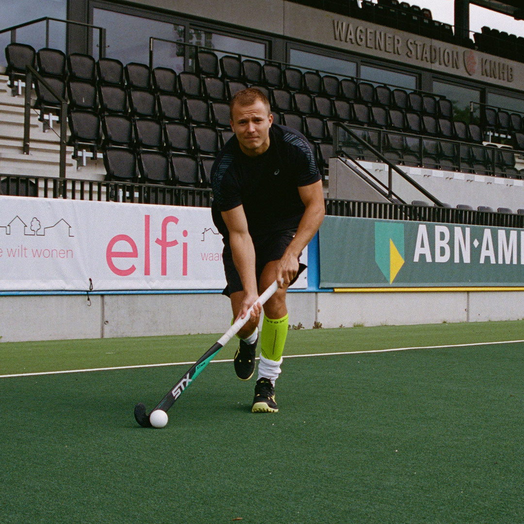 Field hockey player on field in action.