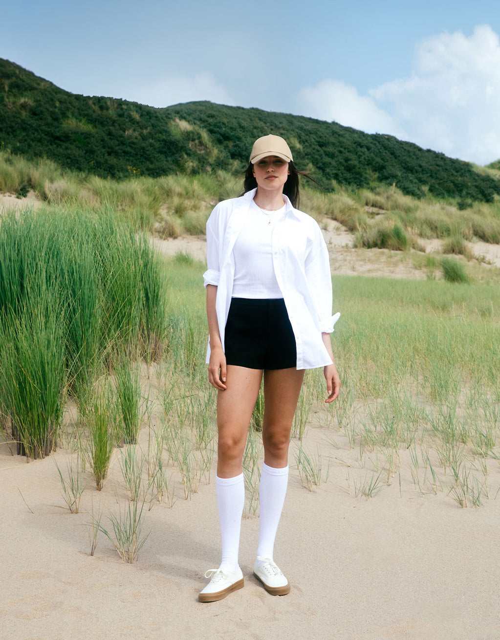 Women standing in the dunes with long socks.