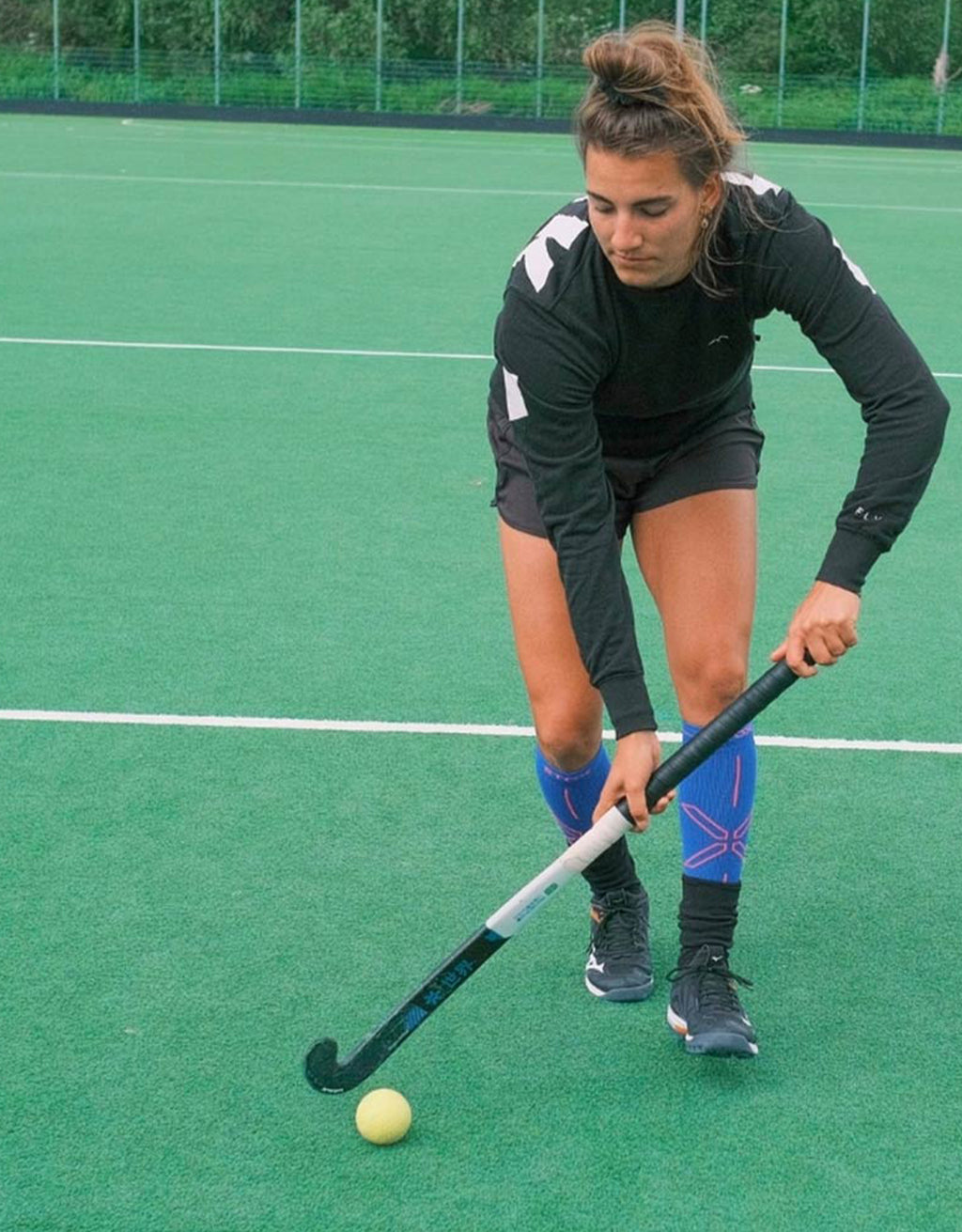 Frédérique Matla is playing field hockey and is wearing blue high socks. 